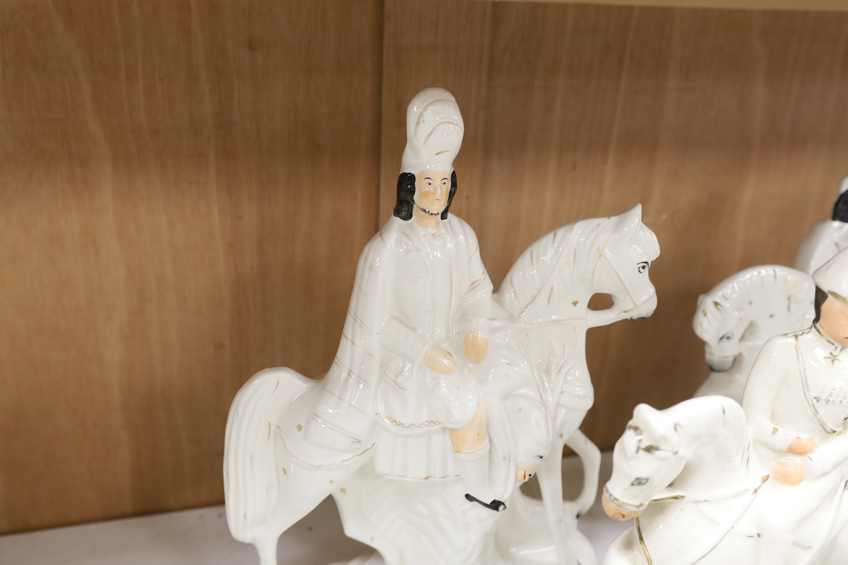 A pair of Staffordshire cow herder figure groups and three Staffordshire equestrian groups, tallest 38cm high